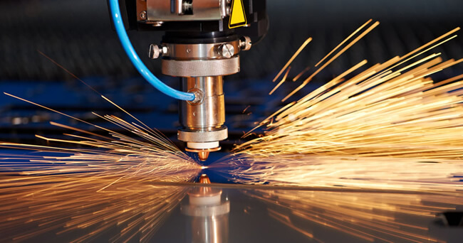 Golden sparks are being emitted from a laser and plasma cutting tool in motion.
