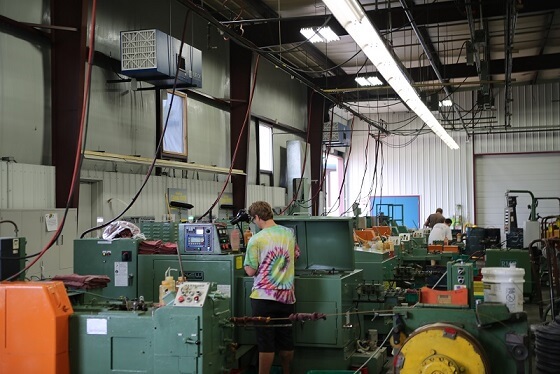 Operator working at cold-header machines with an OX3500C air cleaner mounted overhead
