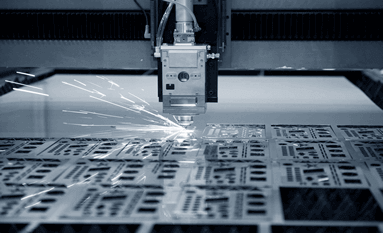 Laser cutting sparks being transmitted from a silver laser cutter and engraving tool in motion.