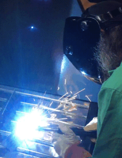 A machine operator working on top of the FumeXtractors dry downdraft table while welding a workpiece.