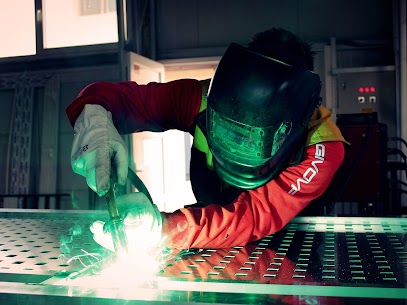 A machine operator welding aluminum in an industrial facility.