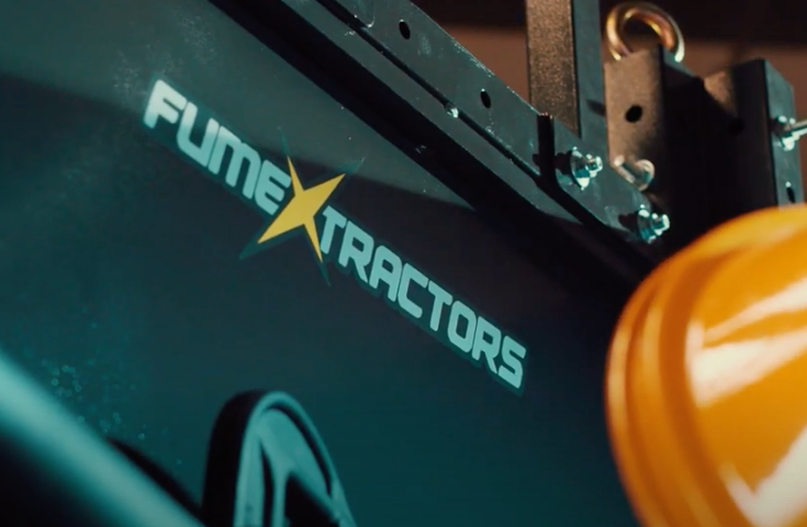 A close-up of a Fume Xtractors welding booth showing the company logo on the side panel with a small snippet of a fume extraction arm.