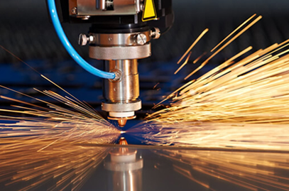 A laser cutting machine in operation while metal sparks emit from the source point.