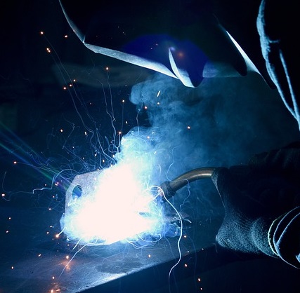 A cloud of welding smoke is generated while a machine operator works on a project.