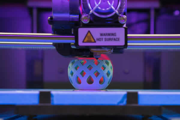A 3D printer in the process of printing a white plastic product.